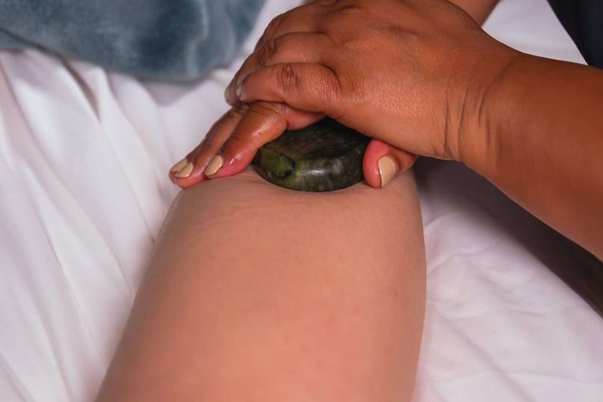A warm basalt stone worked along a client&rsquo;s arm during a hot stone massage in Manotick